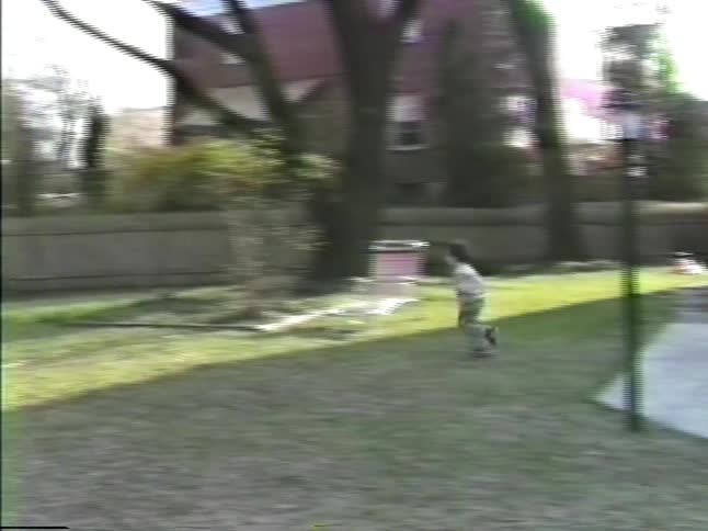 A dad and his kids play in the yard