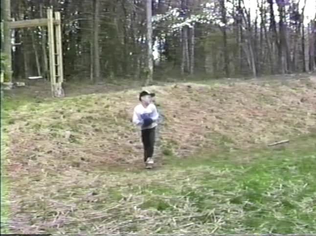 Boy playing in a backyard pitches a baseball
