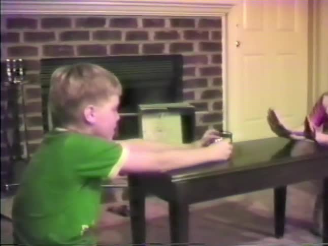 Children sitting face to face interacting over a table in a residential setting