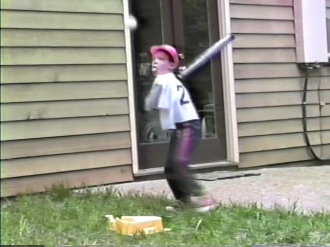 Boy with baseball bat in a backyard