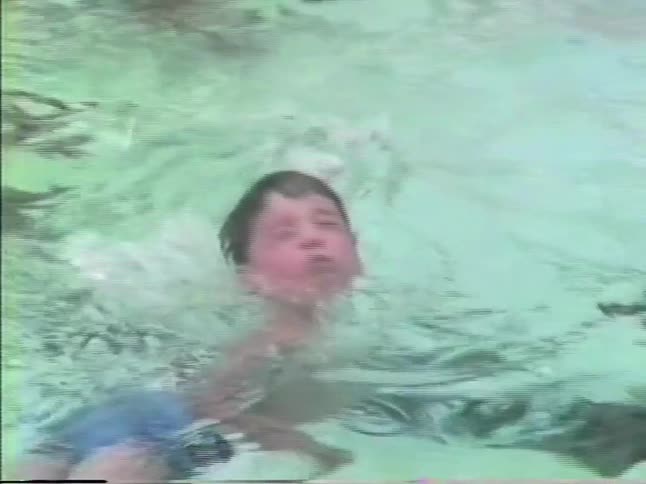Child swimming in a pool with clear water around
