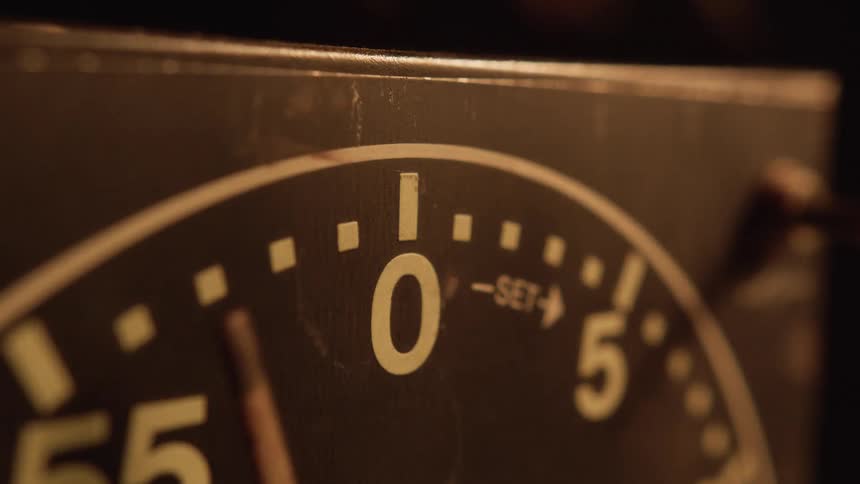Persons finger on a clock as the hand moves backwards