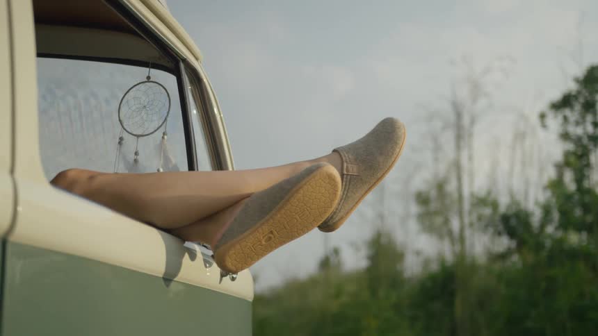 The persons legs are hanging out of the van