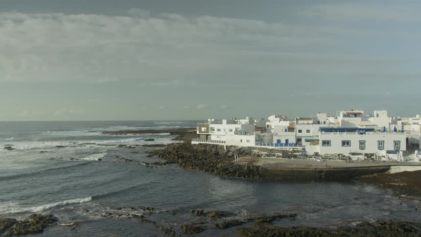 White seaside houses on a rocky coast with gentle waves