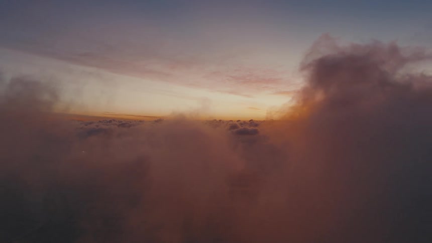 Aerial view through the clouds of snow on mountain rocks