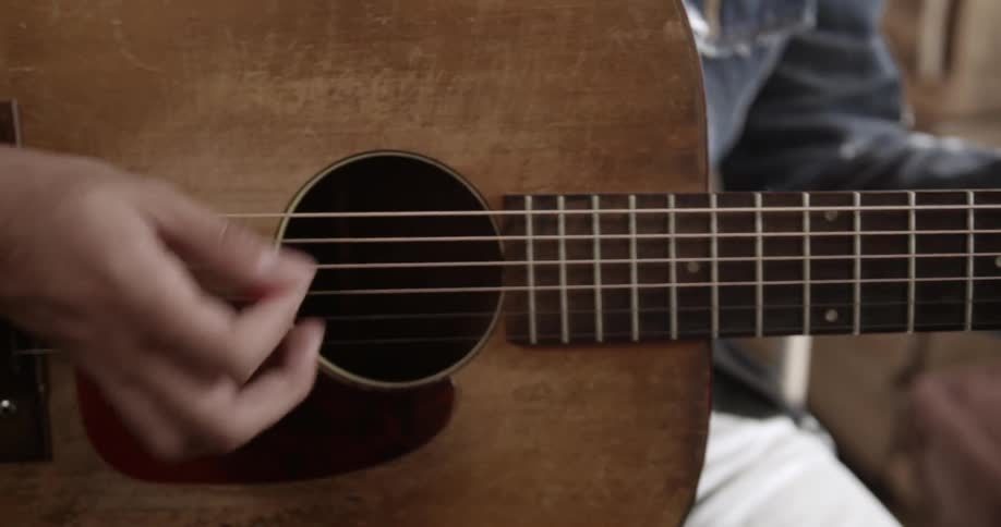 A man strums the strings on his guitar