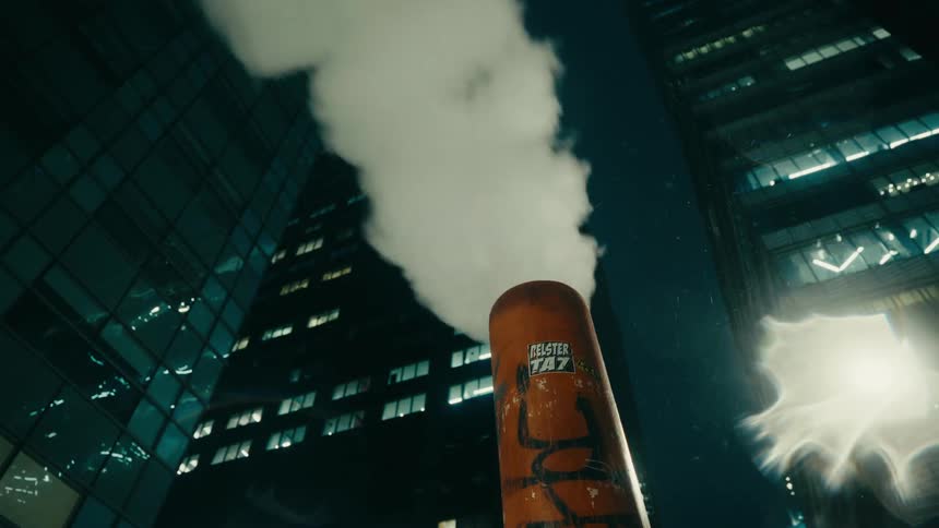 Chimneys spewing smoke as metropolitan buildings light up at night