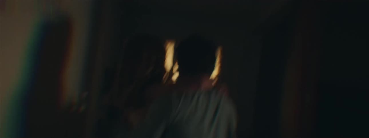 The man runs down the hallway while carrying a girl