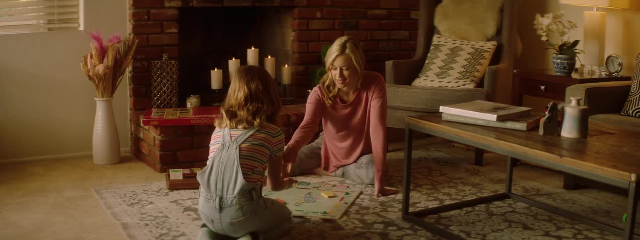 Mother and daughter sitting on the living room rug playing