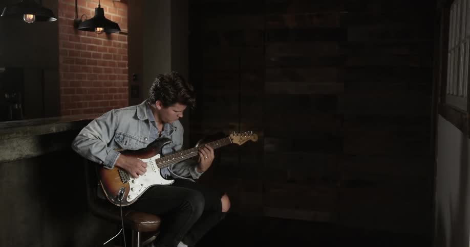 The man is playing an electric guitar