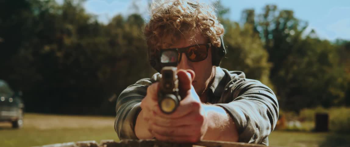 A man practices shooting with a handgun at an outdoor range