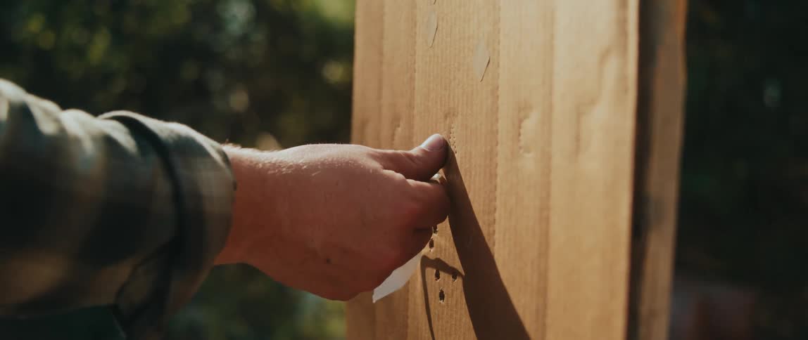 A person putting fabric on a piece of wood
