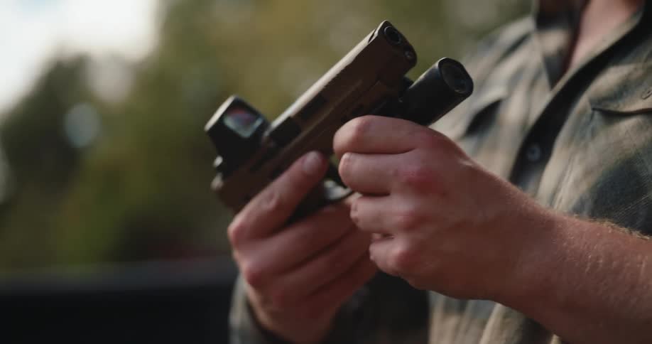 A man holding a handgun outdoors