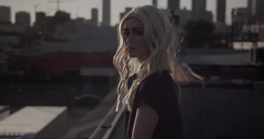 A woman looks out over a rooftop