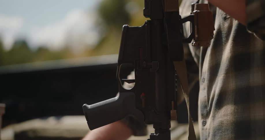 Man picks up a rifle and snaps in the magazine