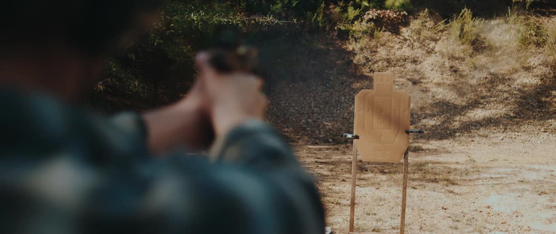 A man shooting at a wooden target