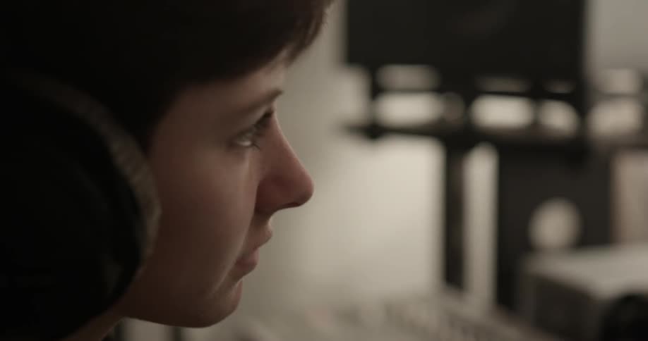 A person wearing headphones nods their head to the music