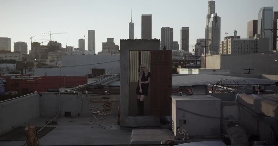 The woman is standing at the doorway of a roof