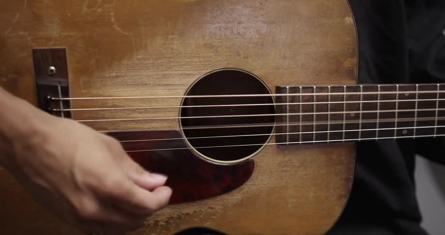 A person plays an acoustic guitar