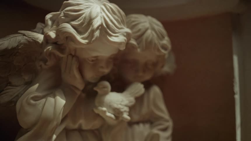 Stone angel sculpture with serene expressions under soft lighting in an indoor setting