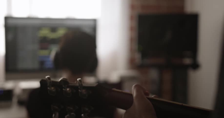 A person plays guitar behind another person
