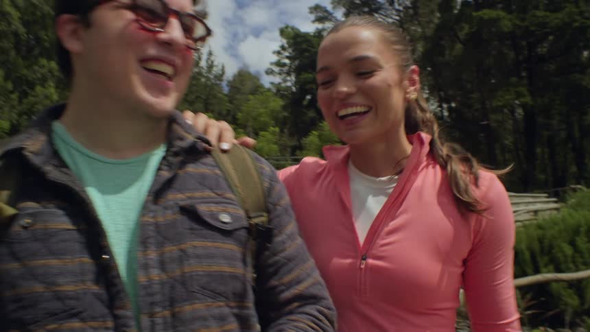 The woman laughs and leans on a mans shoulder
