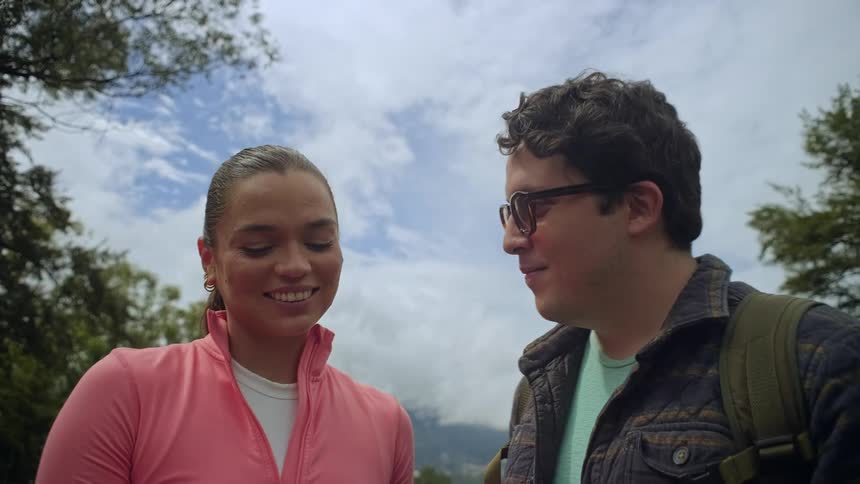 The man and woman talk and smile in the forest