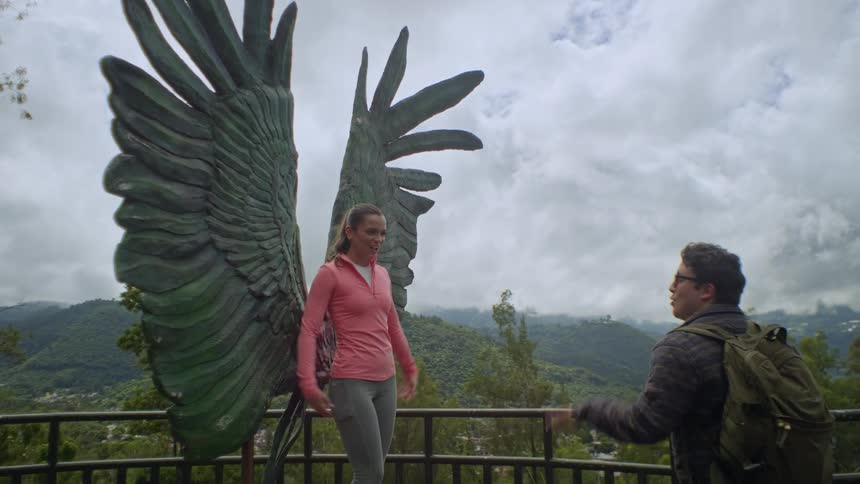A man and woman standing near a statue