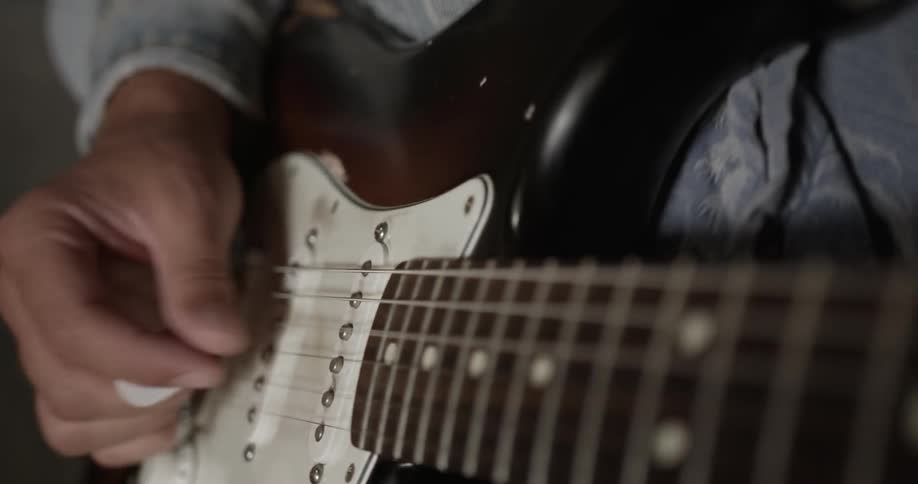 A man strumming an electric guitar
