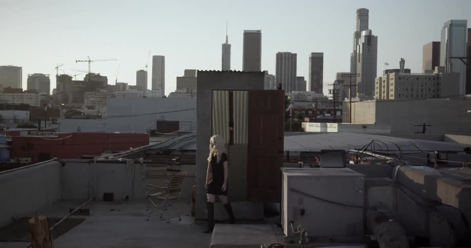 A woman climbs up the steps onto a roof