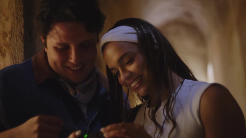 The man and woman laugh while looking at a camera