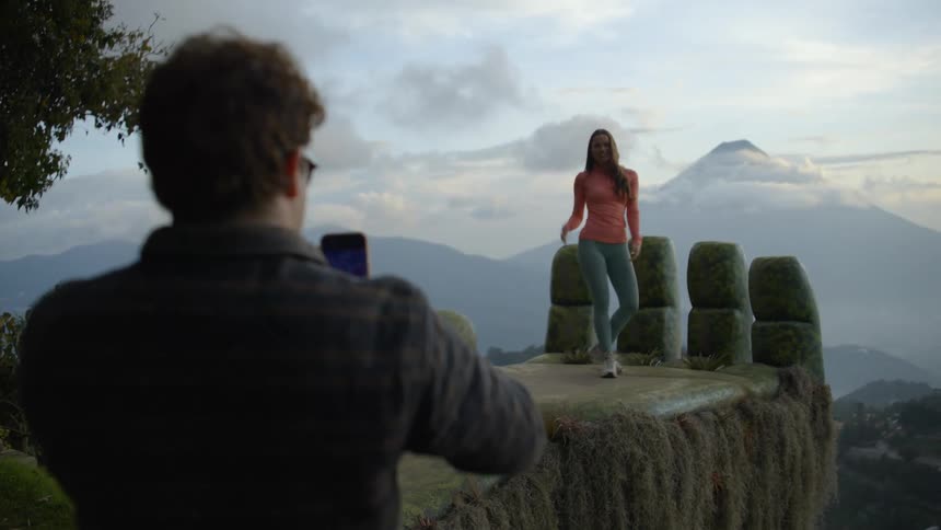 A man taking photos of a woman outdoors