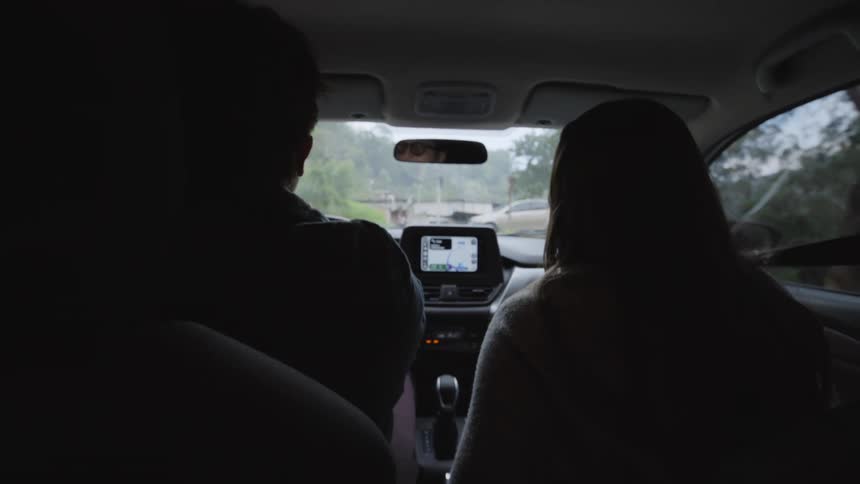 A man and woman in a car driving