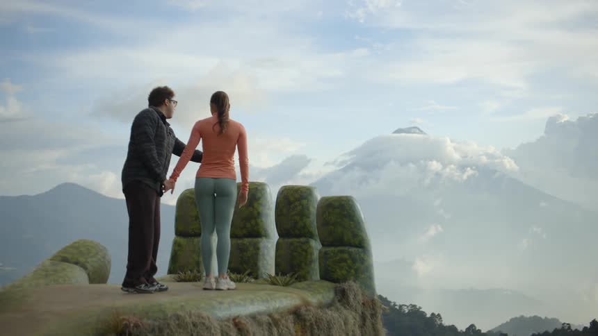 A man and woman stand at a scenic outlook