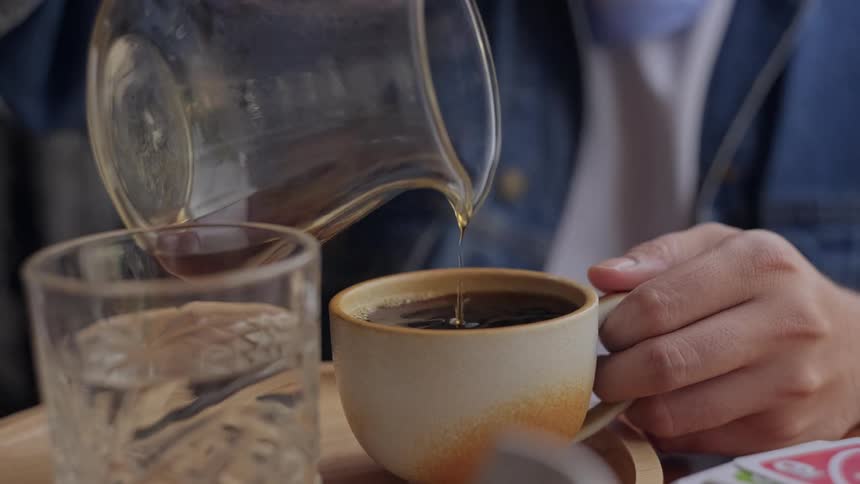 A person pouring a cup of coffee