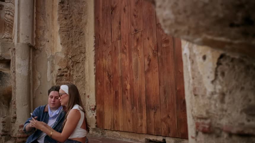 The couple take a selfie in front of the large wooden door