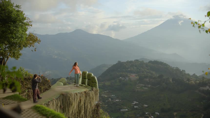 A man taking a photo of a woman outdoors