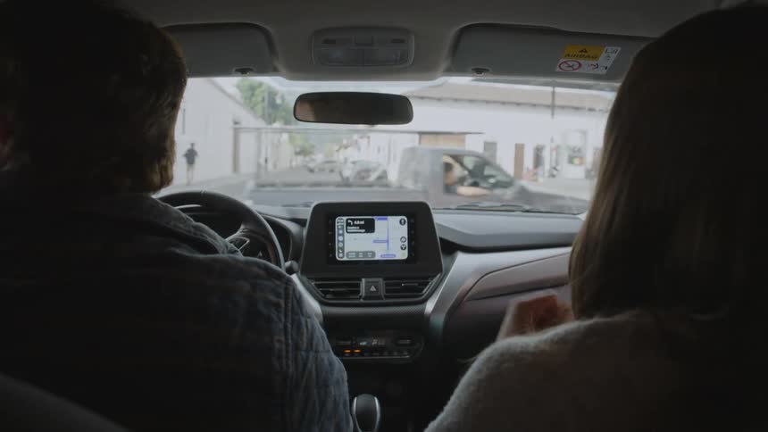 Two people driving in a car in a city