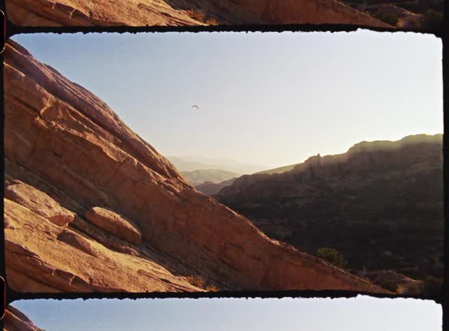 The most dominant line is a sharp diagonal incline created by the massive rock formation on the left side of the frame this line runs from the top left corner down toward the bottom center it is defined by the steep layered surface of the sandstone w
