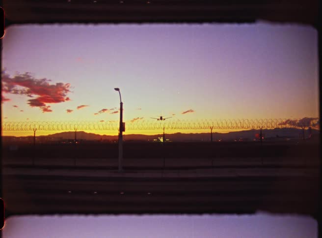 A car drives under an airplane coming in to land