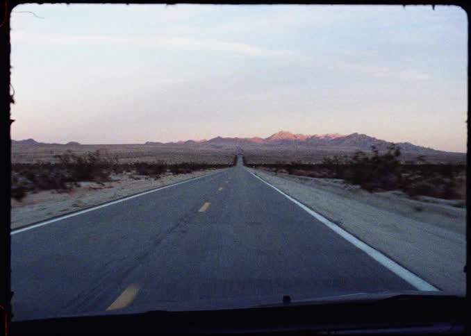 Traveling on a desert highway with mountains in the distance