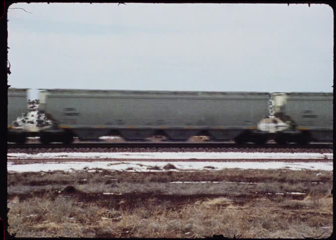 A freight train running down tracks on a snowy day