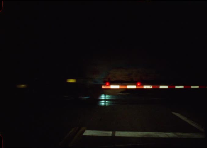 Train crossing a highway at night