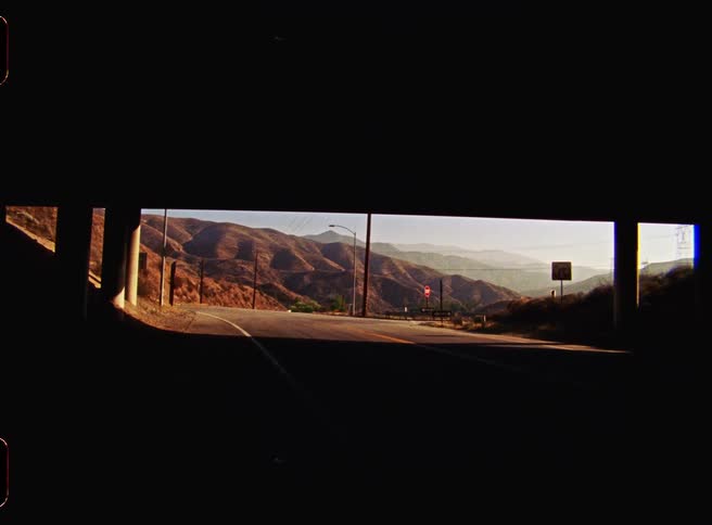View from below an overpass with mountains in the background