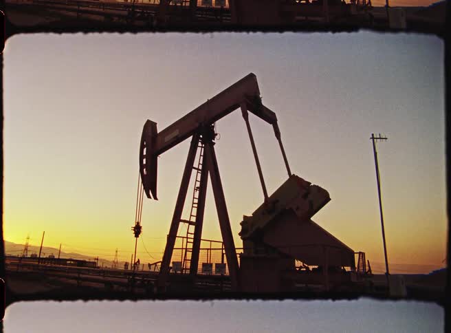 Pumpjack pumping for oil in sunset