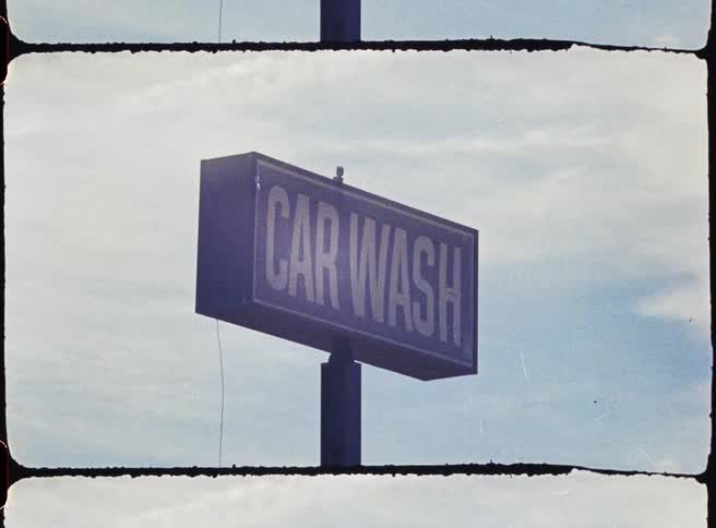 A car wash sign is at the top of the pole