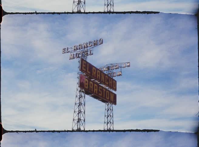 A view of a ranch sign outdoors in a rural area