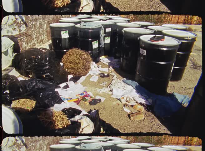 A view of some barrels and trash outdoors