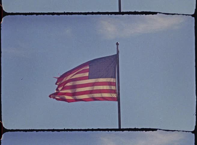 An American flag frayed and torn after years of wind