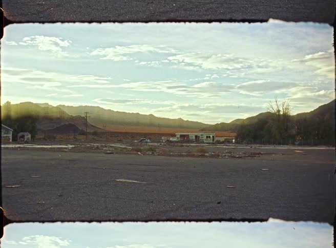 Paved highway with houses in the background and the silhouette of mountains